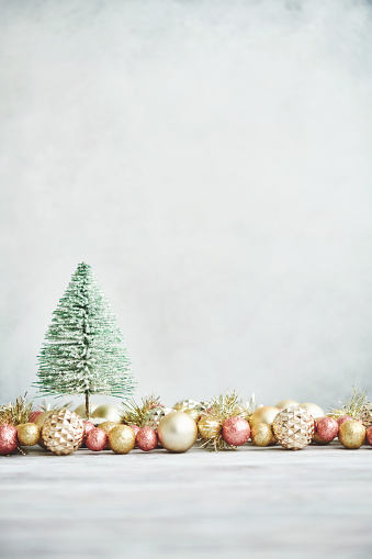 Bright Christmas Background with rose pink and gold decorations with Christmas tree on white wood