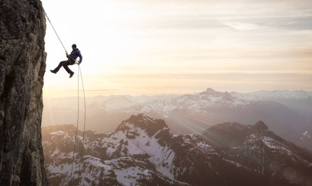 epic adventurous extreme sport composite of rock climbing man rappelling - risk high up sport outdoors fotografías e imágenes de stock