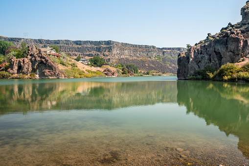 Beautiful summer landscape of the Snake river and sandstone cliffs. Canyon formations reflect in calm river water