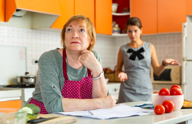 quarrel of an elderly mother and adult daughter in the kitchen - unwillingness imagens e fotografias de stock