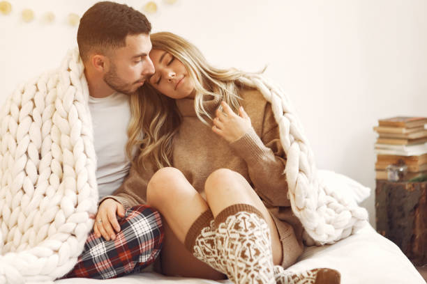 istock Couple sitting on a bed in a room 1271860430