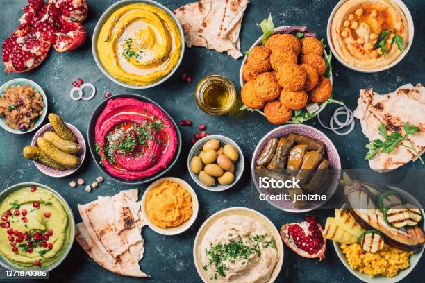 Arabic Traditional Cuisine Middle Eastern Meze With Pita Olives Colorful Hummus Falafel Stuffed Dolma Babaganush Pickles Vegetables Pomegranate Eggplants Mediterranean Appetizer Party Idea Stock Photo - Download Image Now