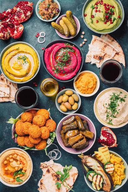 istock Mediterranean appetizer concept. Arabic traditional cuisine. Middle Eastern meze with pita, olives, hummus, stuffed dolma, falafel balls, pickles, babaganush, vegetables, pomegranate, eggplants 1271870451