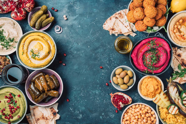 istock Mediterranean appetizer concept. Arabic traditional cuisine. Middle Eastern meze with pita, olives, hummus, stuffed dolma, falafel balls, pickles, babaganush, vegetables, pomegranate, eggplants 1271870506