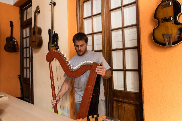 istock Young instrument maker holding harp at studio 1271871257
