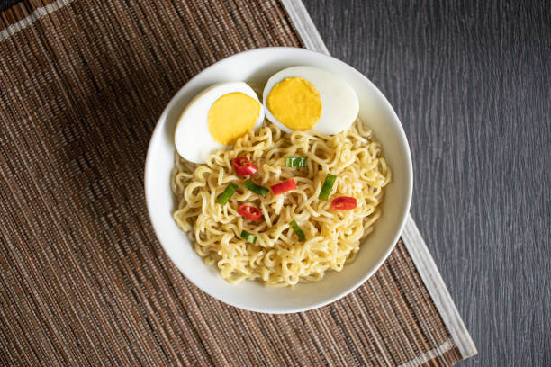 istock Indonesian indomie instant fried noodle with sunny side up egg served on white chicken illustrated bowl 1271874658