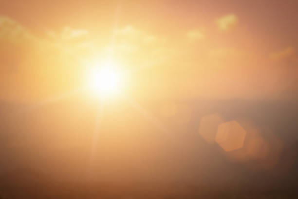 Natural background blurring warm colors and bright gold sunlight. Bokeh or Christmas background Green Energy at sky sunny color orange light patterns plain abstract flare evening clouds blur.