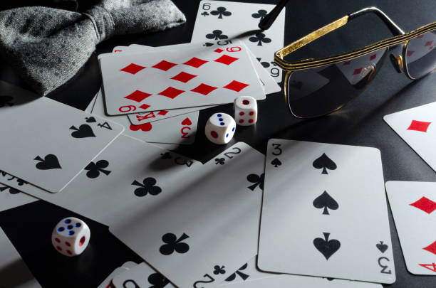 nahaufnahme von spielkarte, würfel, brille, fliege auf dem schwarzen schreibtisch. konzept des pokerclubs - table house of cards strategy business stock-fotos und bilder