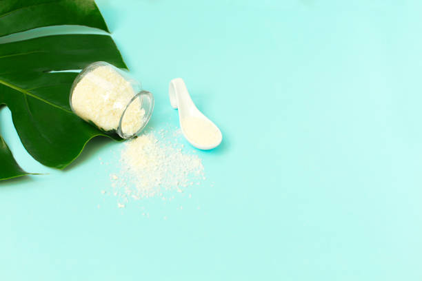 istock A jar with collagen powder with spoon or protein on blue background. 1271879130