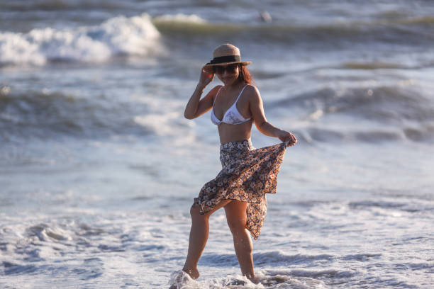 istock Beautiful young woman relaxing at sunset beach 1271879495