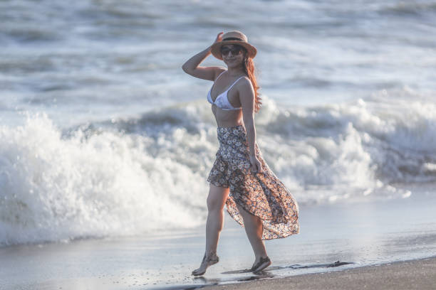 istock Beautiful young woman relaxing at sunset beach 1271880195