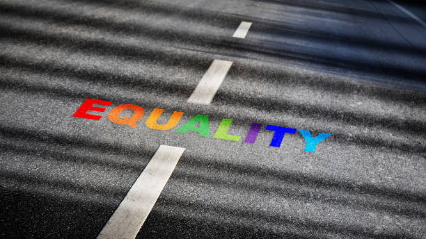 Equality word with white dividing lines on black asphalt road surface with sunlight Social issue concept and lgbt idea racial equality photos stock pictures, royalty-free photos & images