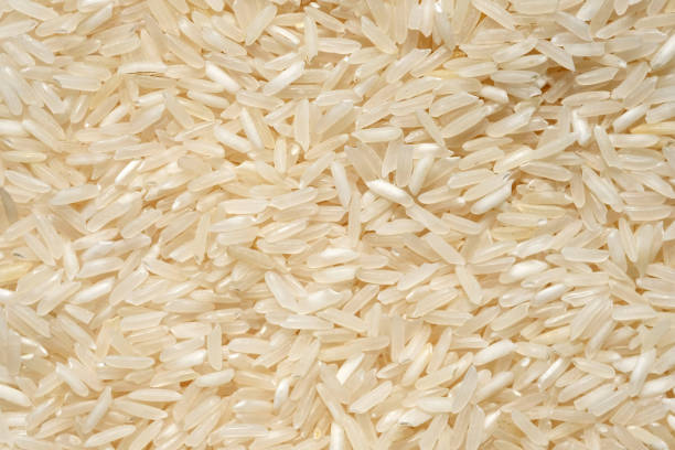 istock Long grain rice top view. Dry white rice grains close up background. 1271882960
