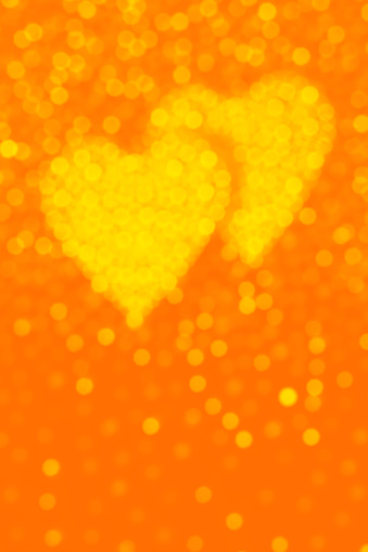 Two glittering hearts on a sparkling defocused background. Beautiful bokeh. Space for copy.
