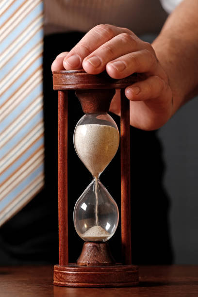 homme d’affaires avec un sablier - sand clock human hand hourglass photos et images de collection