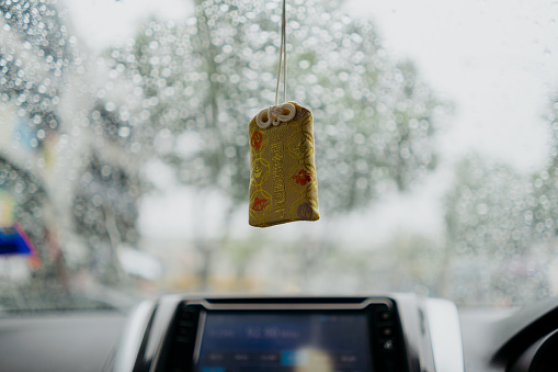Religious amulet hanging in car blessing for a safe journey on road