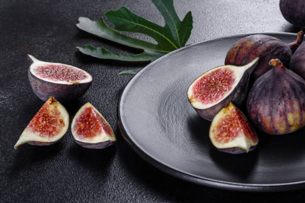 istock Fresh ripe figs on a dark concrete background. Harvesting figs 1271890926