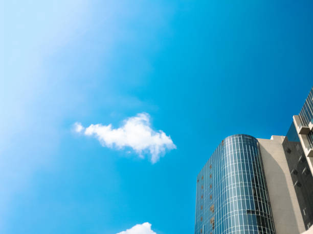 Modern high-rise buildings with glass windows and reflection, blue sky at bright summer day