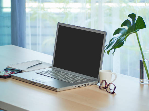 istock Laptop with blank screen mockup on table at home 1271893683