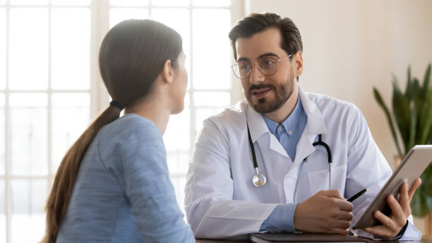 istock Doctor therapist consulting patient at meeting, using computer tablet 1271897788