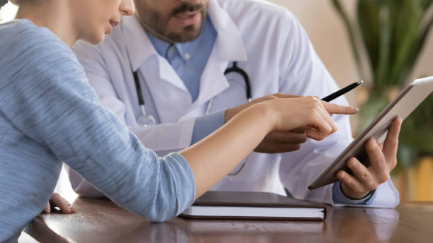 istock Close up doctor therapist consulting female patient, using tablet 1271897804