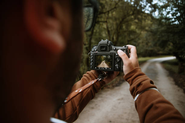 istock Rear view of a man using a DSLR camera 1271898867