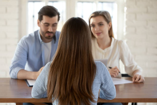 istock Rear view two hr managers interviewing young woman candidate 1271899117