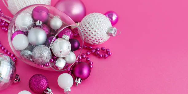 istock Christmas baubles in a wine glass on a pink background 1271900562