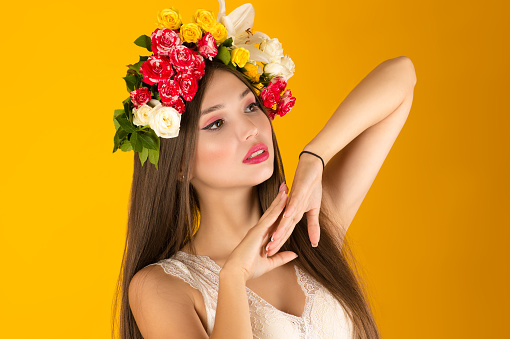 beautiful woman with flowers on head cut out on yellow background
