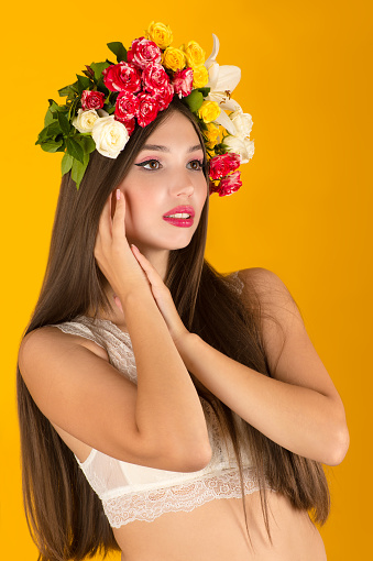 charming woman with flowers on head cut out on yellow background