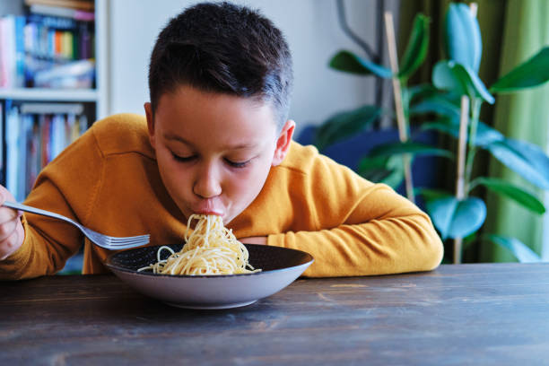 istock Child is eating spaghetti. He is very happy. 1271902110