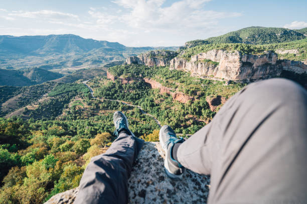 First person perspective shot from a hiker sitting at the edge of a cliff at Siurana medieval town, catalonia, Spain stock photo