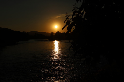 Beautiful Sunset over the River Drina in Serbia with the river stream in sunbeams
