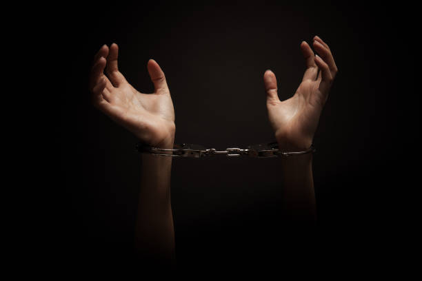 istock Woman with handcuff over the black background 1271903651