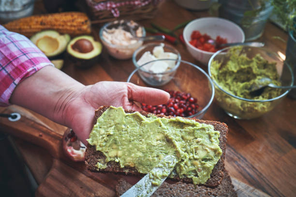 istock Preparing Avocado Sandwich with Brown Bread and Pomegranate 1271904564