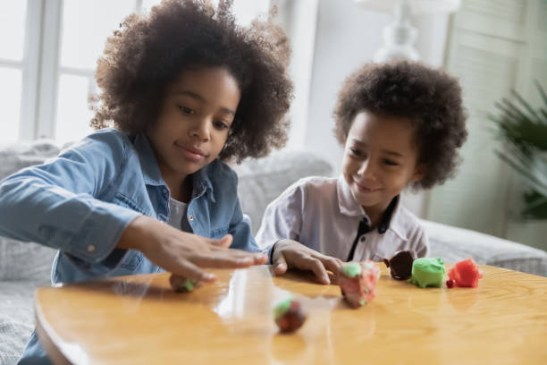 istock Happy african american children involved in creating figures with plasticine. 1271905948