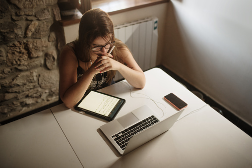 Young woman working or studying with a laptop and a tablet PC at home