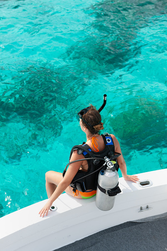 woman diver gettting ready for scuba dive in the caribbean, st. john, united states virgin islands