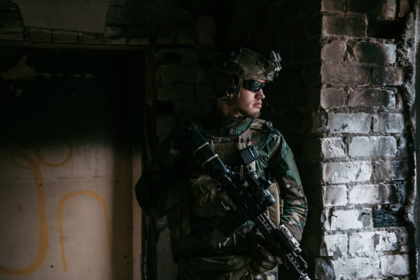 A thoughtful soldier, resting from a military operation while it is raining outside