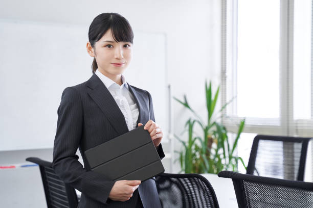オフィスでタブレットを持つ日本の女性ビジネスウーマン - 文書係 ストックフォトと画像