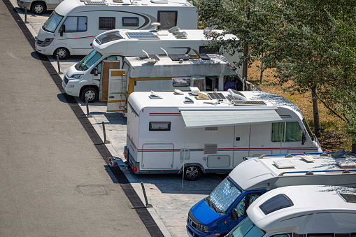 View of motorhomes parked on the side of the road in foreign tourists campsite...