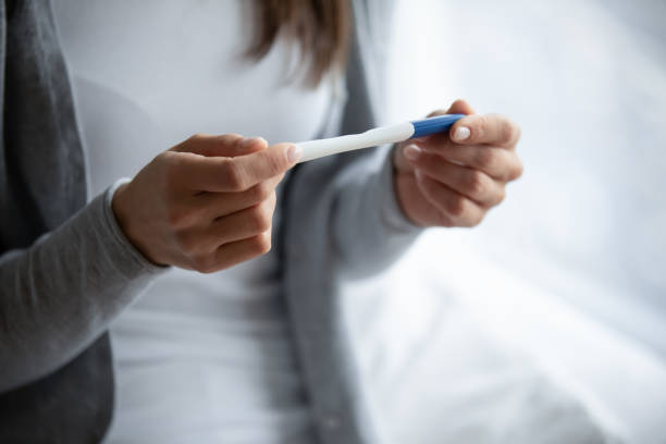 istock Close up young woman holding plastic pregnancy test in hands 1271917048