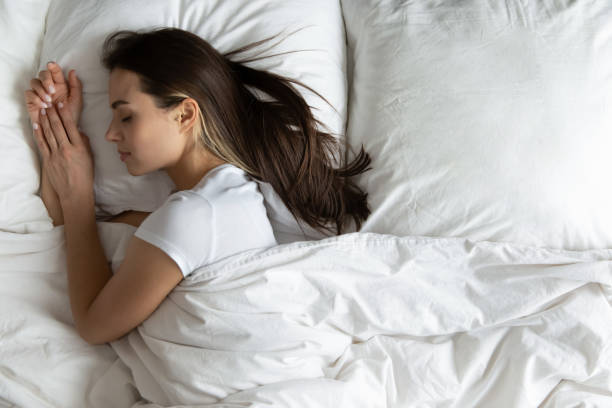 istock Top view peaceful young woman sleeping on side in bed 1271917087
