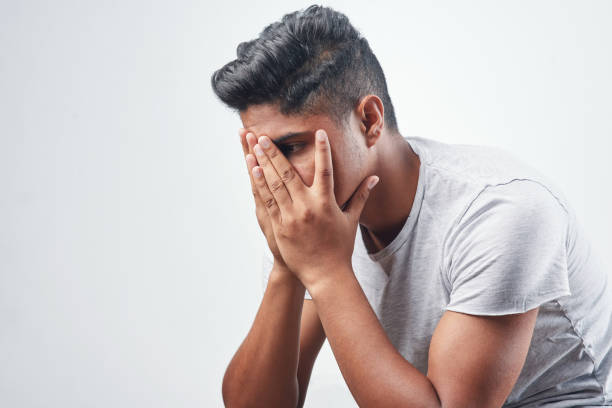 Studio shot of a young man sitting against a white background