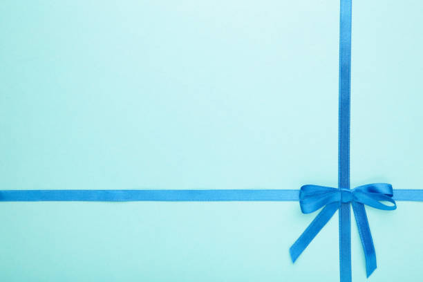 istock Blue ribbon with a bow as a gift on a blue pastel background. 1271923370