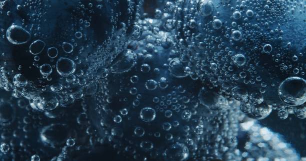 blaue trauben im sodawasser. extreme nahaufnahme - amerikanische heidelbeere fotos stock-fotos und bilder