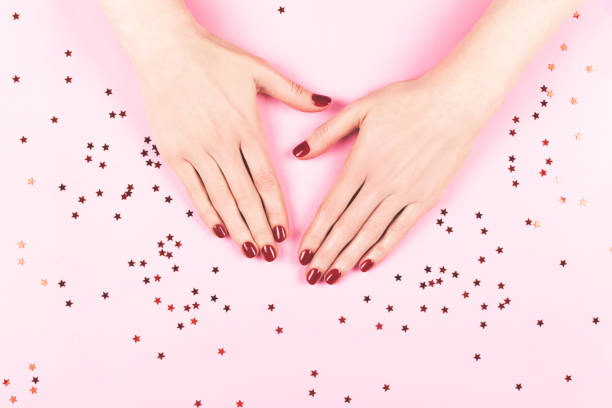 istock Two woman hands and falling confetti on pink background. 1271926652