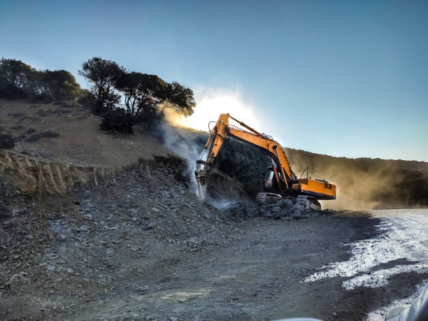 macchina da costruzione che decostruisce il terreno naturale - earth mover working field dirt foto e immagini stock