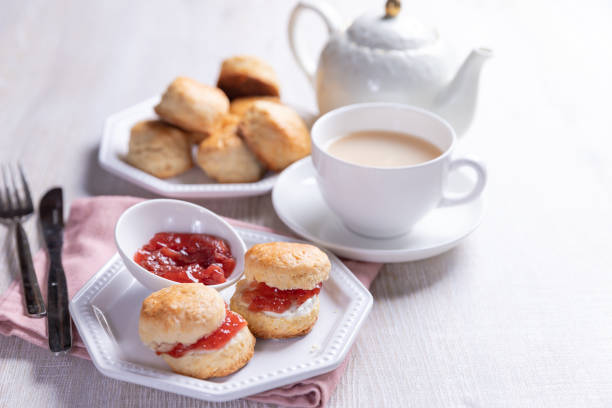 focaccine inglesi con crema e marmellata servite con tazza di tè sul tavolo bianco. - afternoon tea scone tea cream foto e immagini stock