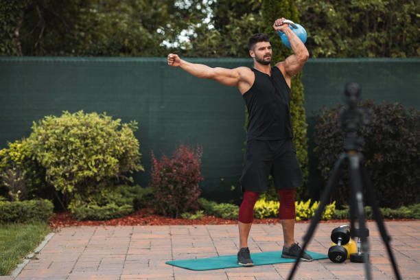 istock Male athlete doing exercise in backyard and filming vlog. 1271931820